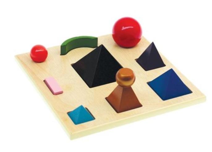 Montessori grammar symbols: wooden shapes including pyramids, spheres, a crescent and a bar on a tray